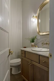 a bathroom with a toilet a sink and mirror