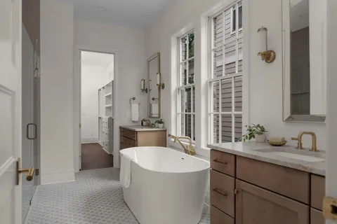 a bathroom with a tub sink shower and mirror