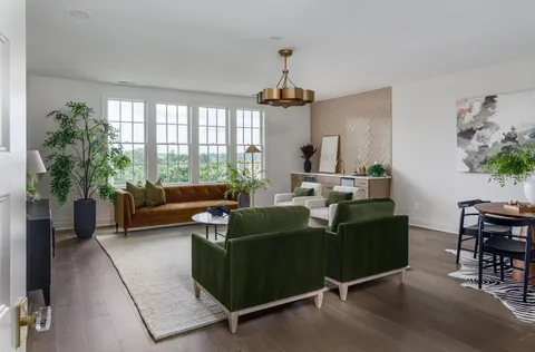 a living room with furniture a window and potted plant