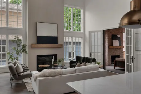 a living room with furniture a fireplace and a large window