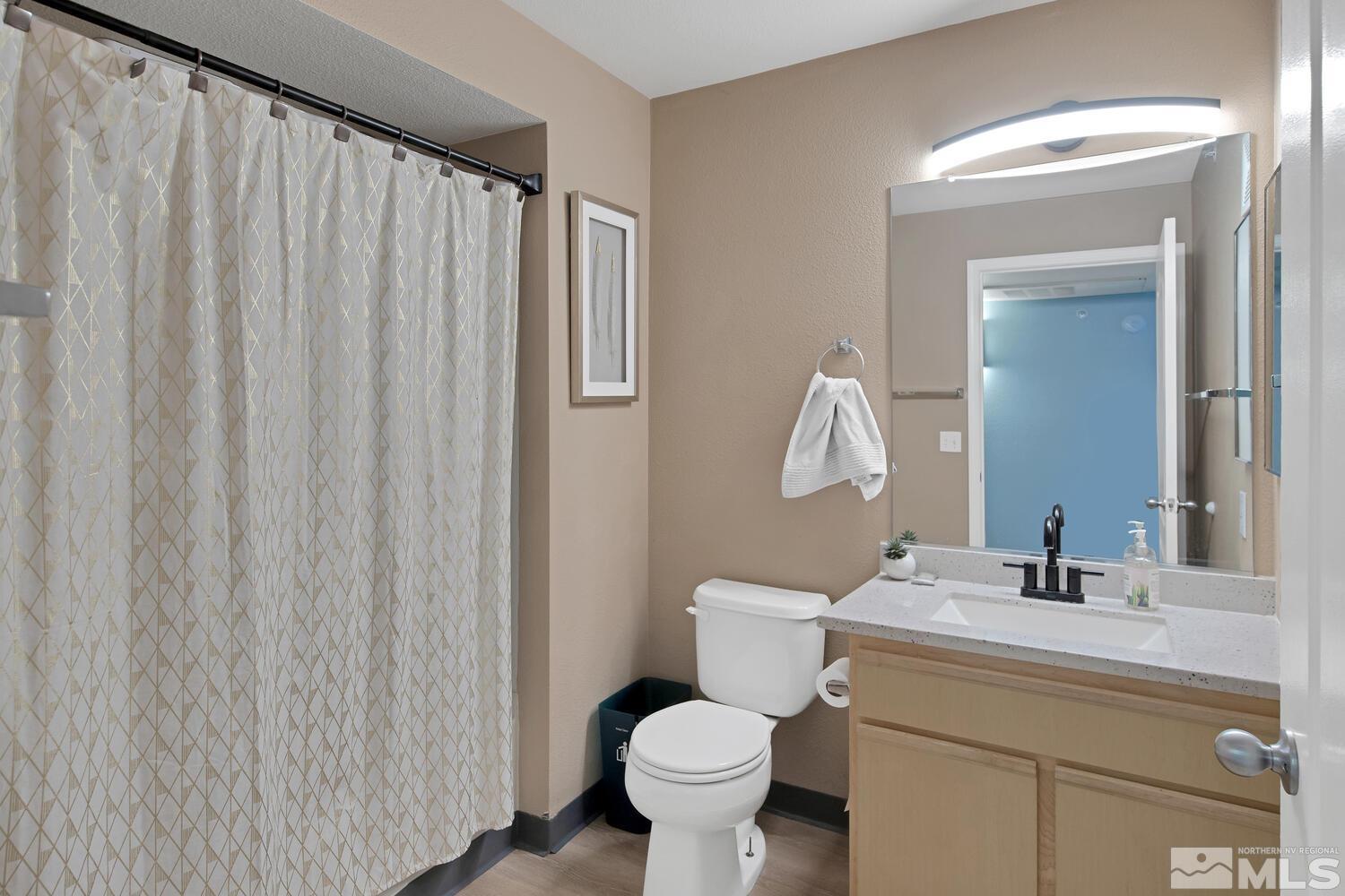 6850 Sharlands Avenue, Unit N2081 Reno, NV 89523 - Photo 15 of 27 a bathroom with a sink a toilet and a mirror