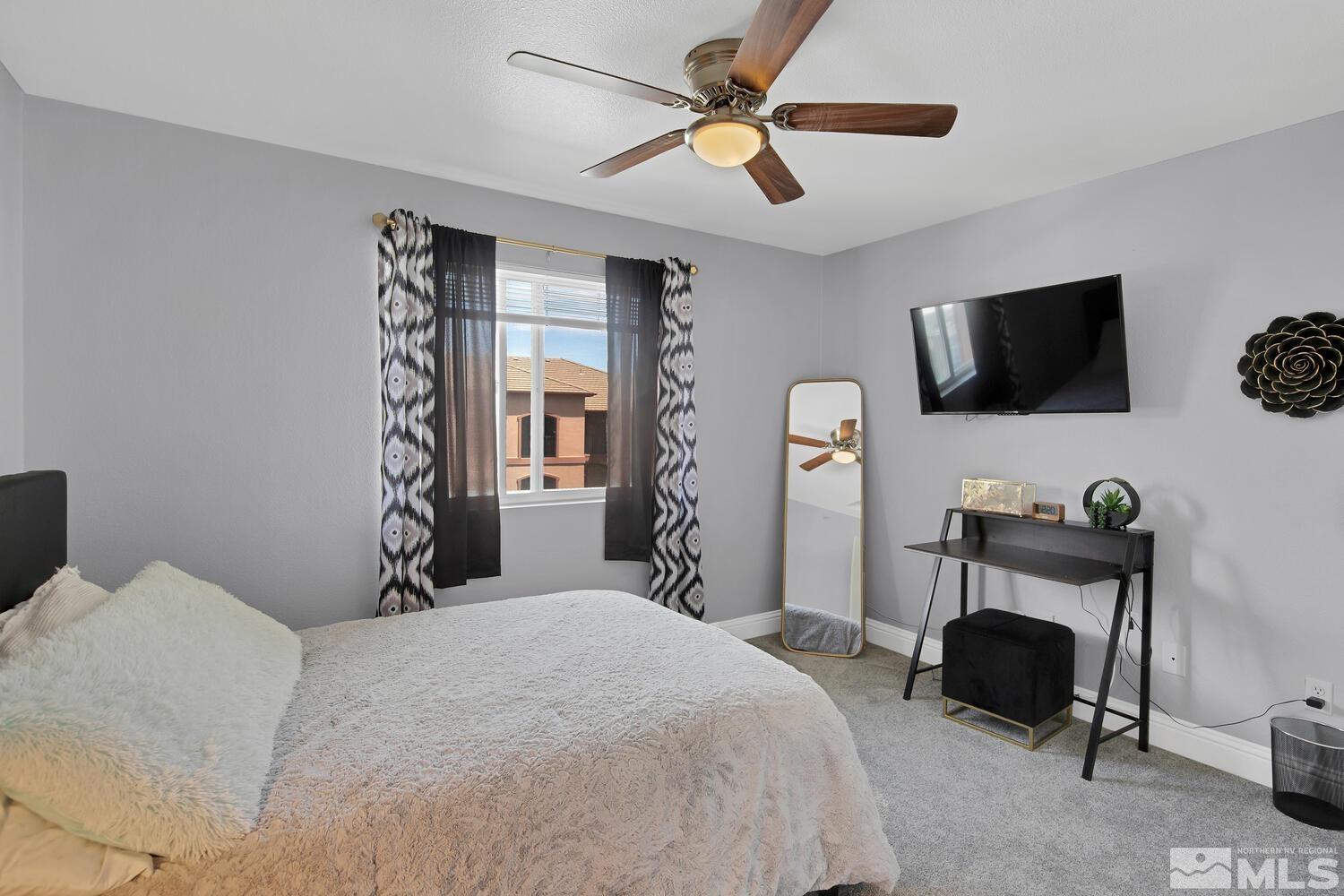 6850 Sharlands Avenue, Unit N2081 Reno, NV 89523 - Photo 18 of 27 a bedroom with a bed window and a flat screen tv