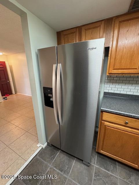 4721 Sisson Road Titusville, FL 32780 - Photo 7 of 29 a view of a refrigerator in kitchen and an empty room with wooden floor