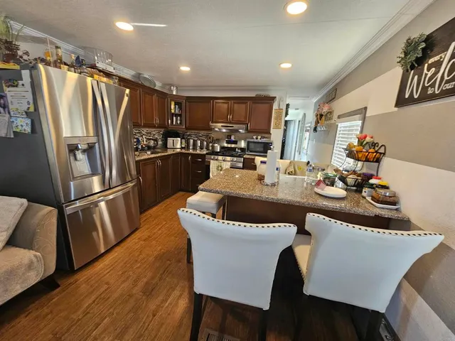 a kitchen with a table chairs refrigerator and microwave