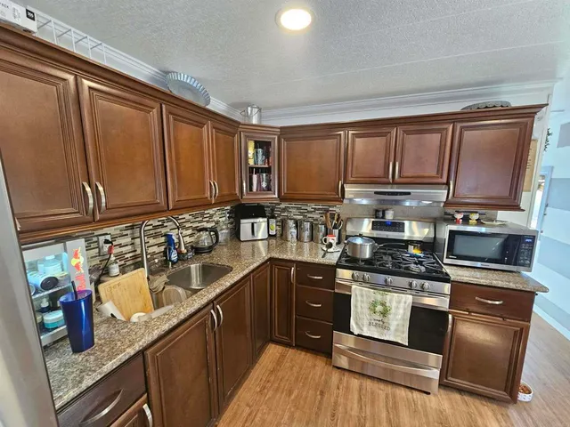 a kitchen with stainless steel appliances granite countertop a sink stove and refrigerator