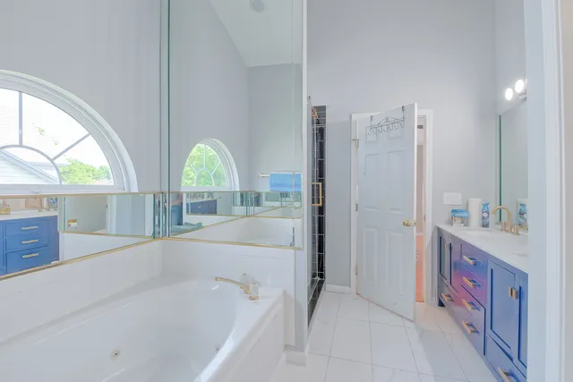 a spacious bathroom with a tub sink and mirror