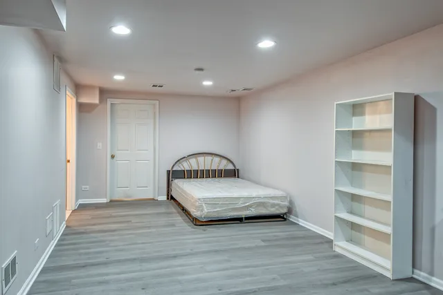 a view of a bedroom with wooden floor and closet