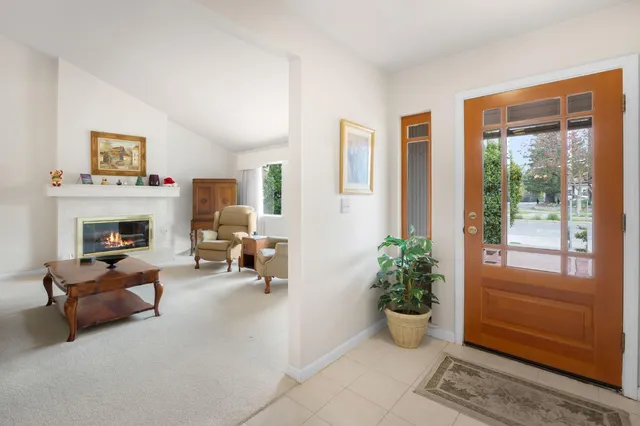 a living room with furniture fireplace and a large window