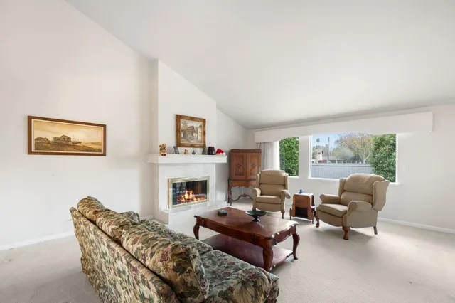 a living room with furniture a fireplace and a table