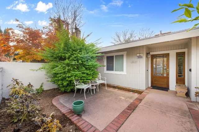 a view of a patio with table and chairs and floor to ceiling window and buildings