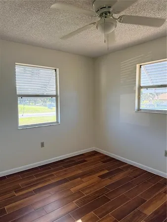 a room with wooden floor and windows
