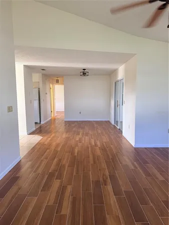 a view of a big room with wooden floor and windows