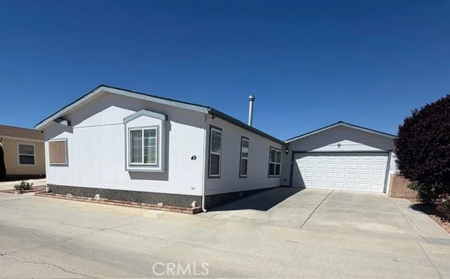 22241 Nisqually Road East, Unit 49 Apple Valley, CA 92308 - Photo 1 of 2 a front view of a house with a yard