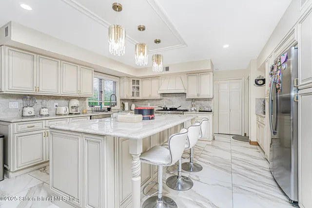 a kitchen with a dining table chairs and refrigerator