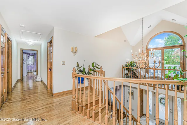 a bedroom with a bed and a dresser with wooden floor