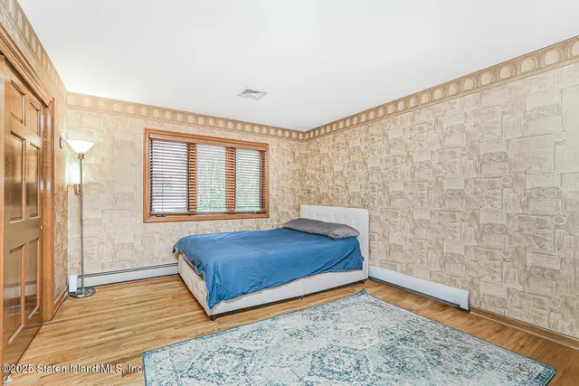 a spacious bedroom with a bed and a dresser