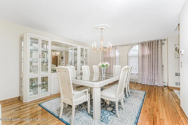 a dining room with furniture a chandelier and wooden floor