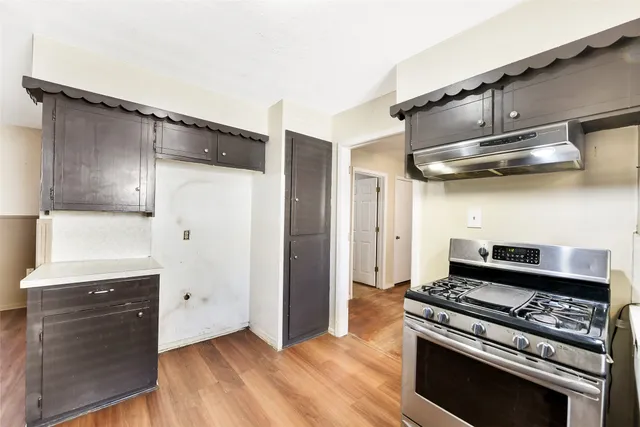 a kitchen with wooden cabinets and a stove top oven