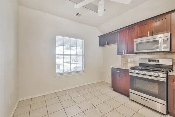 a kitchen with cabinets appliances and a window
