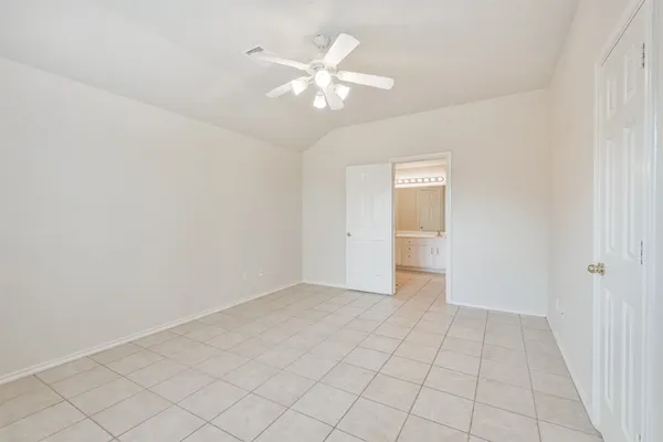 a view of an empty room with chandelier fan