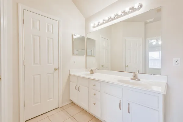 a bathroom with a double vanity sink and a mirror
