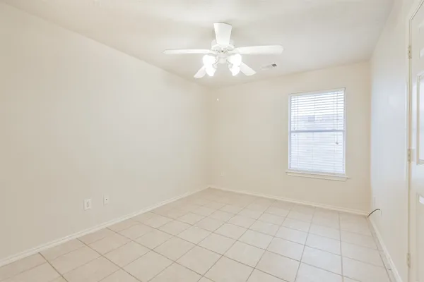 an empty room with windows and fan