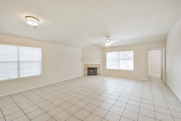 an empty room with windows and fireplace
