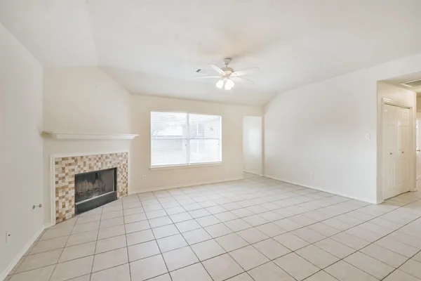 an empty room with windows and fireplace