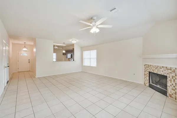 an empty room with windows and fireplace