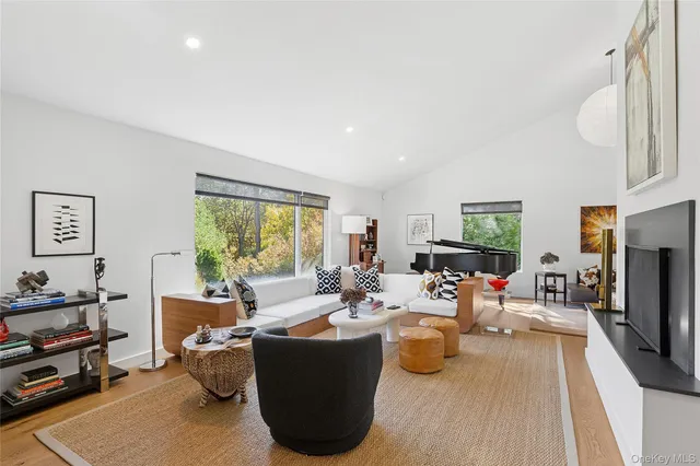 a living room with fireplace furniture and a large window