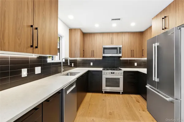a kitchen with stainless steel appliances granite countertop a sink stove and refrigerator