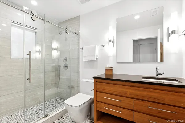 a bathroom with a sink a toilet and shower