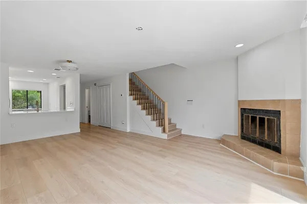 an empty room with windows and a fireplace