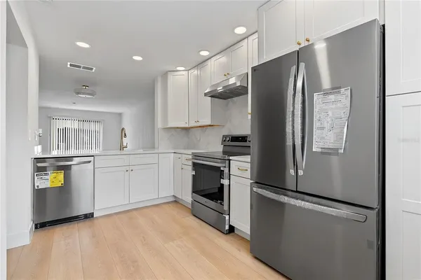 a kitchen with stainless steel appliances a refrigerator and a stove top oven