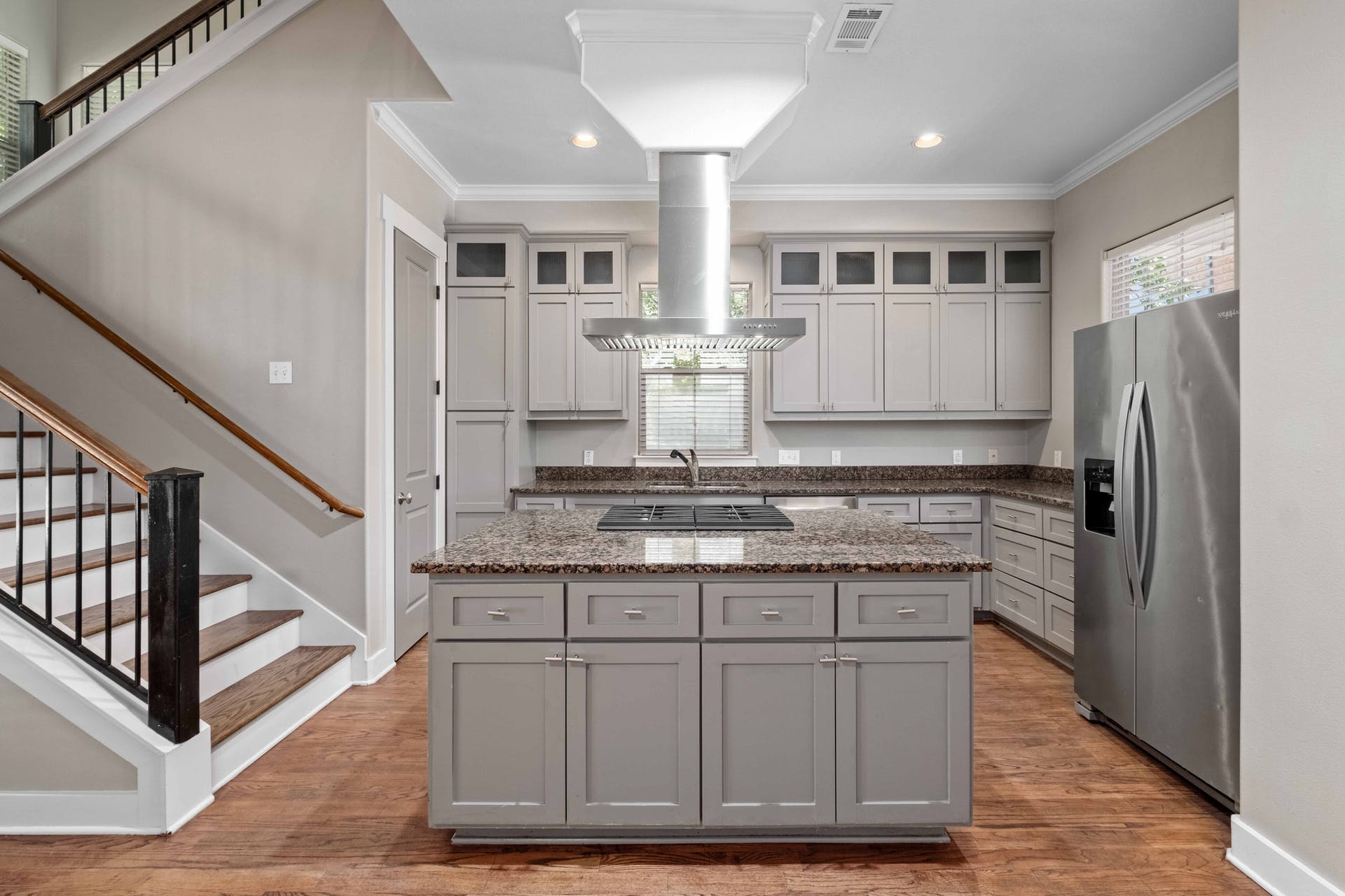 2309 A Longview Street, Unit A Austin, TX 78705 - Photo 2 of 13 a kitchen with kitchen island granite countertop wooden cabinets and a refrigerator