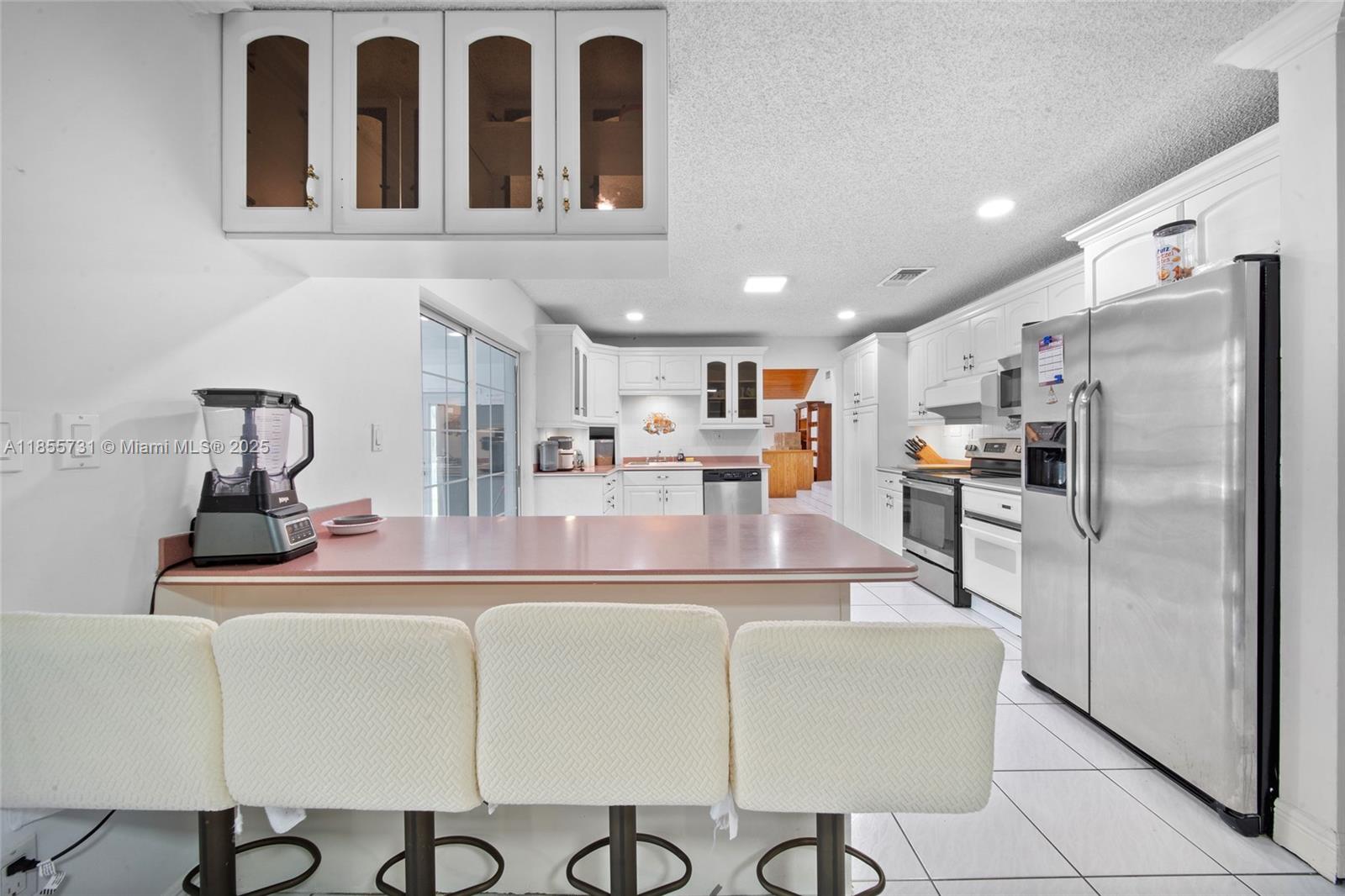 10723 Southwest 142nd Court Miami, FL 33186 - Photo 25 of 54 a kitchen with stainless steel appliances granite countertop a refrigerator and a stove top oven