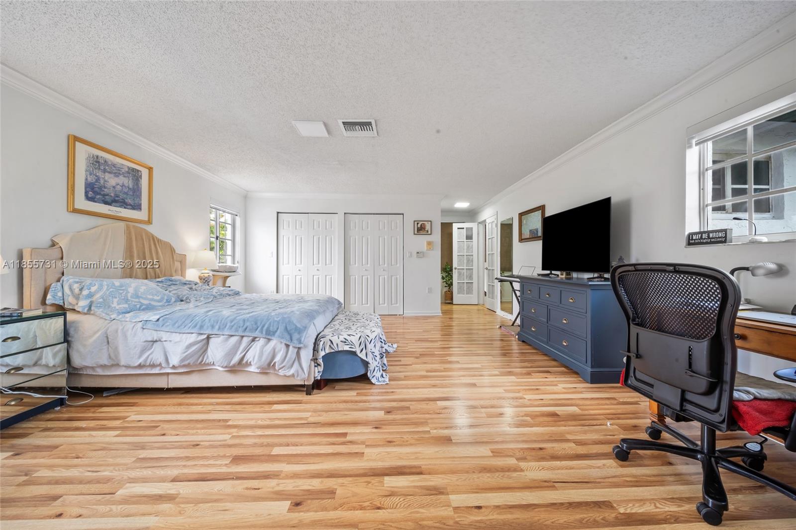 10723 Southwest 142nd Court Miami, FL 33186 - Photo 44 of 54 a spacious bedroom with a bed and a flat screen tv