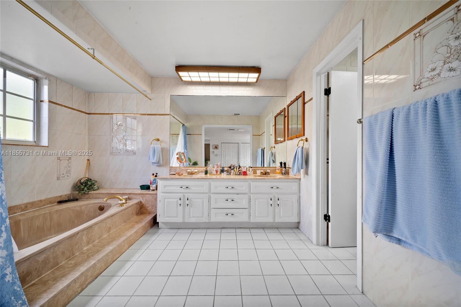 10723 Southwest 142nd Court Miami, FL 33186 - Photo 45 of 54 a large white bathroom with a large mirror vanity and bathtub