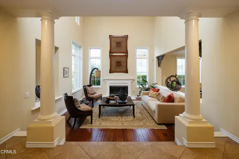 a dining room with furniture a chandelier and wooden floor