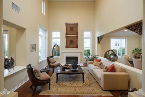a living room with furniture fireplace and a large window