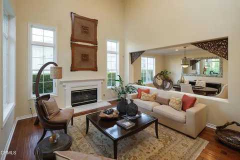 a living room with furniture fireplace and a large window
