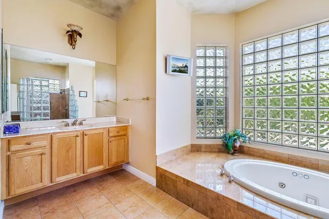 a spacious bathroom with a granite countertop tub sink and mirror
