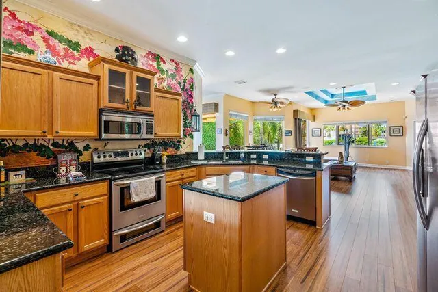 a kitchen with stainless steel appliances granite countertop sink stove top oven and cabinets