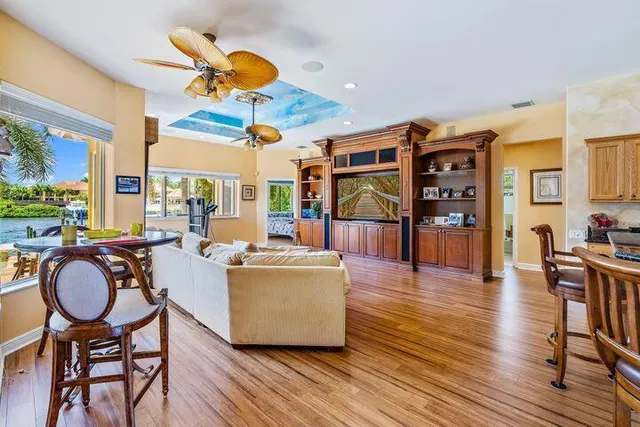 a living room with furniture a rug potted plant and a large window