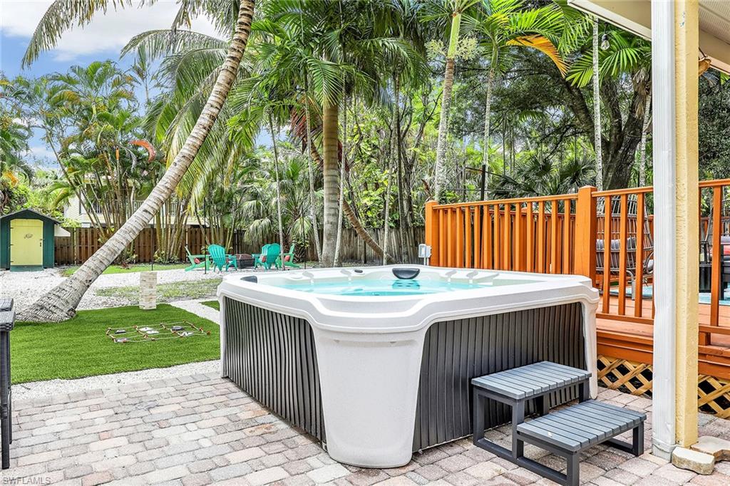 2780 Weeks Avenue Naples, FL 34112 - Photo 25 of 34 a view of a patio with a table and chairs under an umbrella with wooden fence