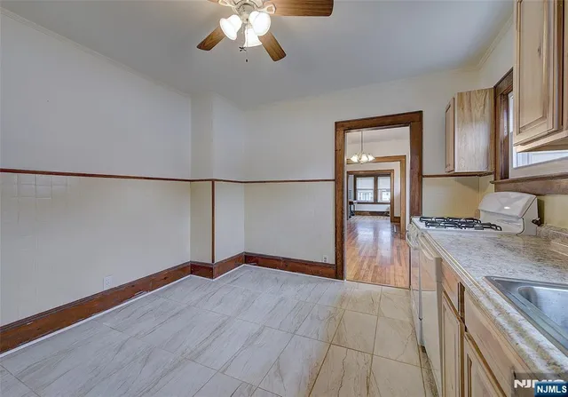 a kitchen with granite countertop a stove a refrigerator and a stove with wooden floor