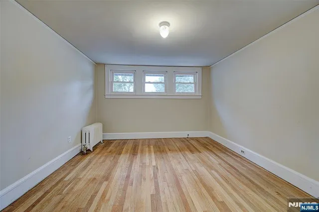 a view of a room with wooden floor and windows