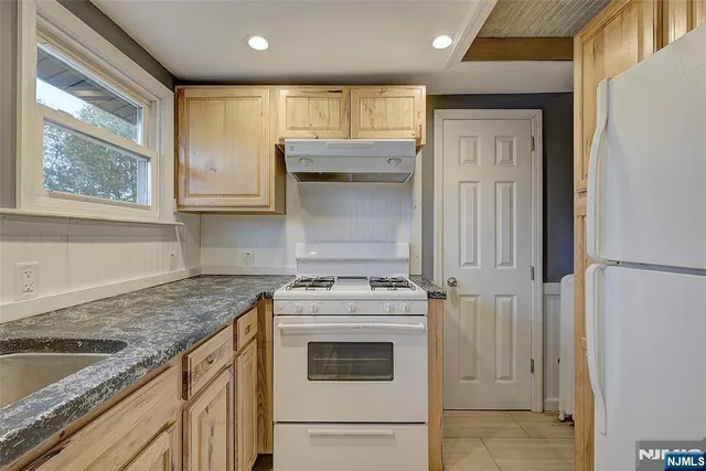 a kitchen with granite countertop cabinets stainless steel appliances and a sink