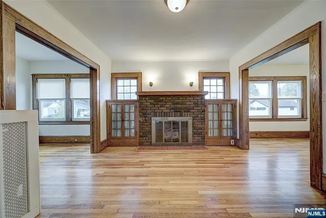 a view of a livingroom with wooden floor and a fireplace
