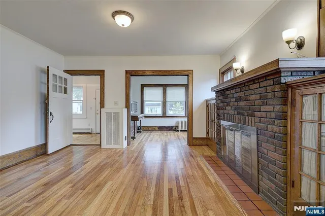 an empty room with wooden floor and fireplace